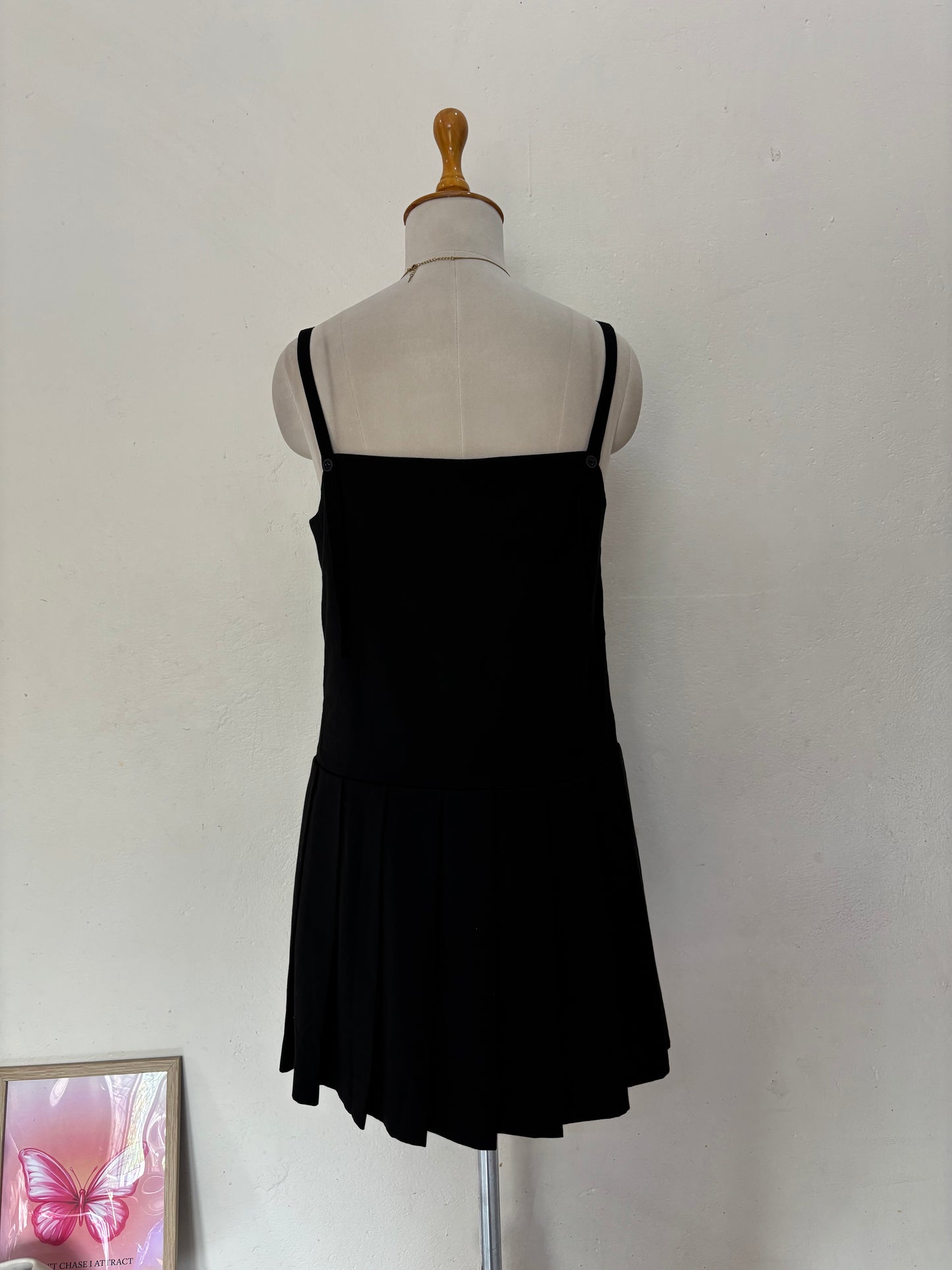 Black short straight cut dress with pleated bottom skirt.