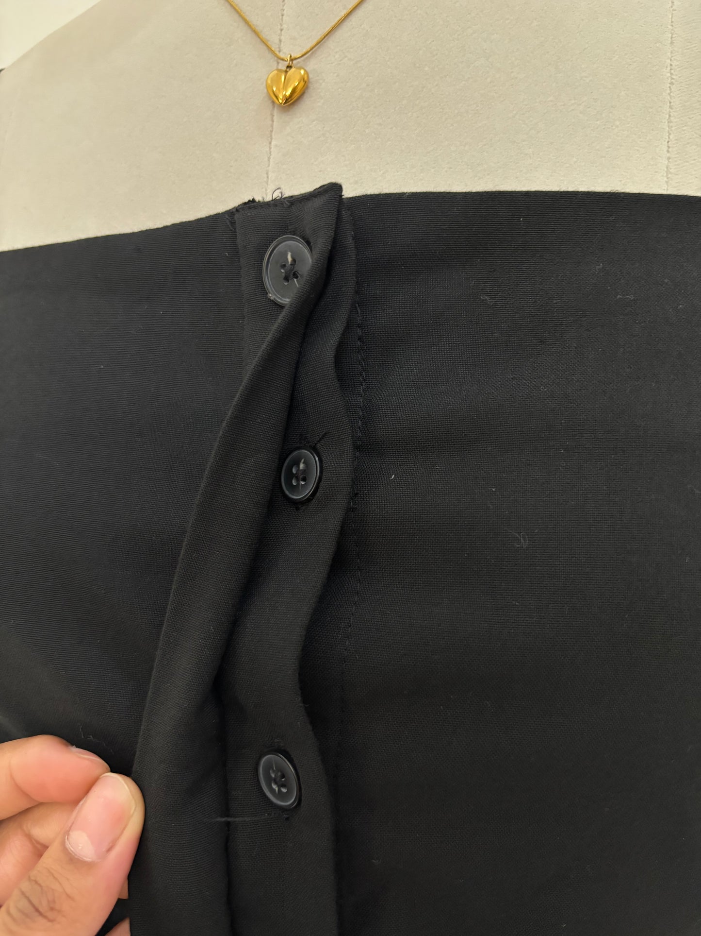 Black short straight cut dress with pleated bottom skirt.