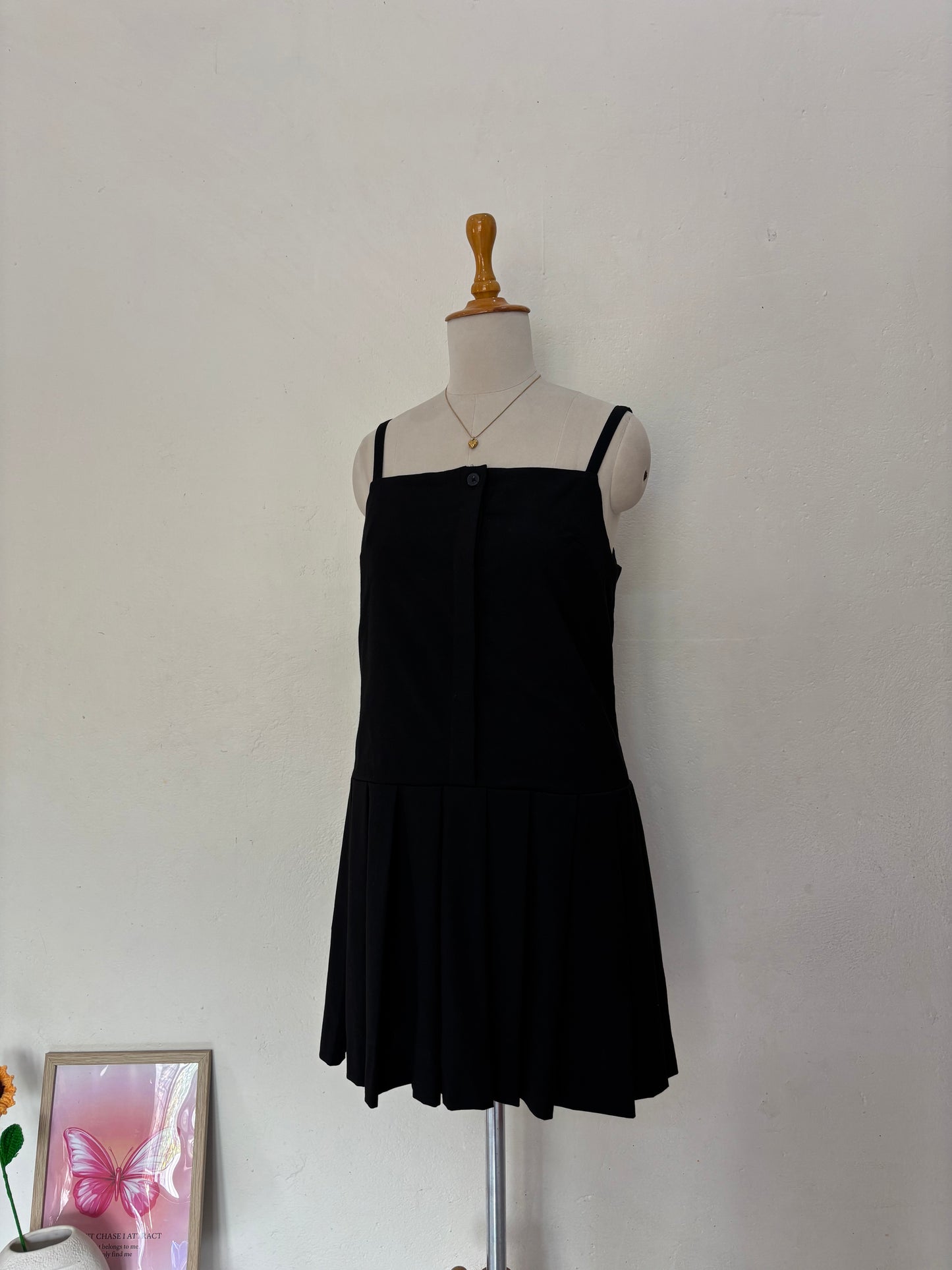 Black short straight cut dress with pleated bottom skirt.