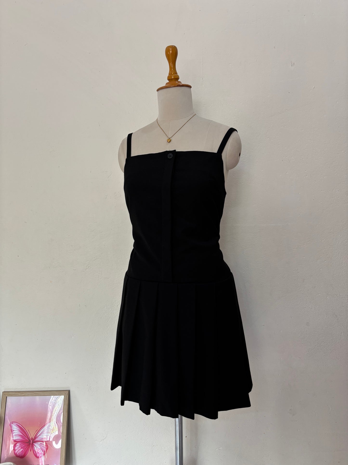 Black short straight cut dress with pleated bottom skirt.