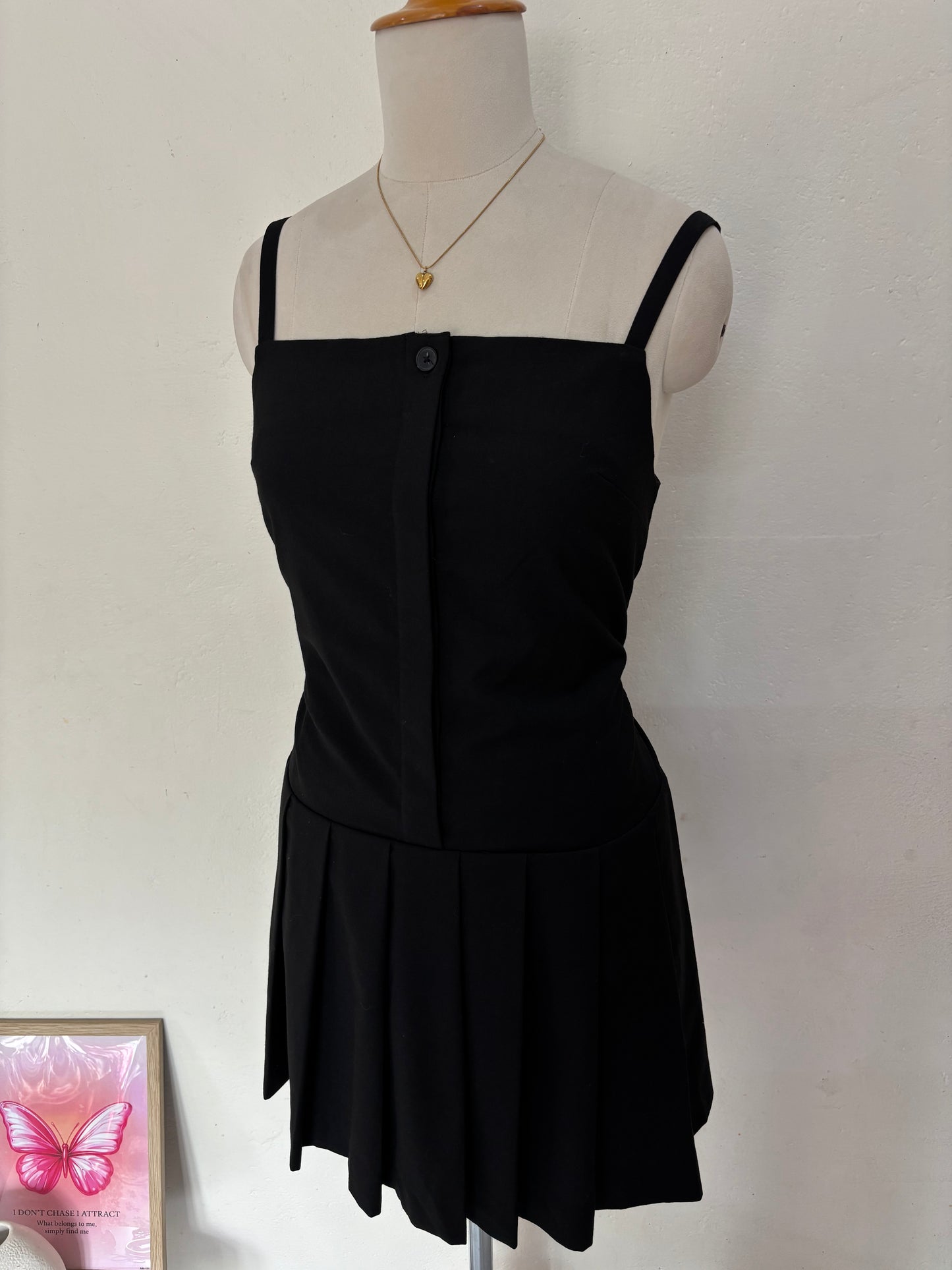 Black short straight cut dress with pleated bottom skirt.
