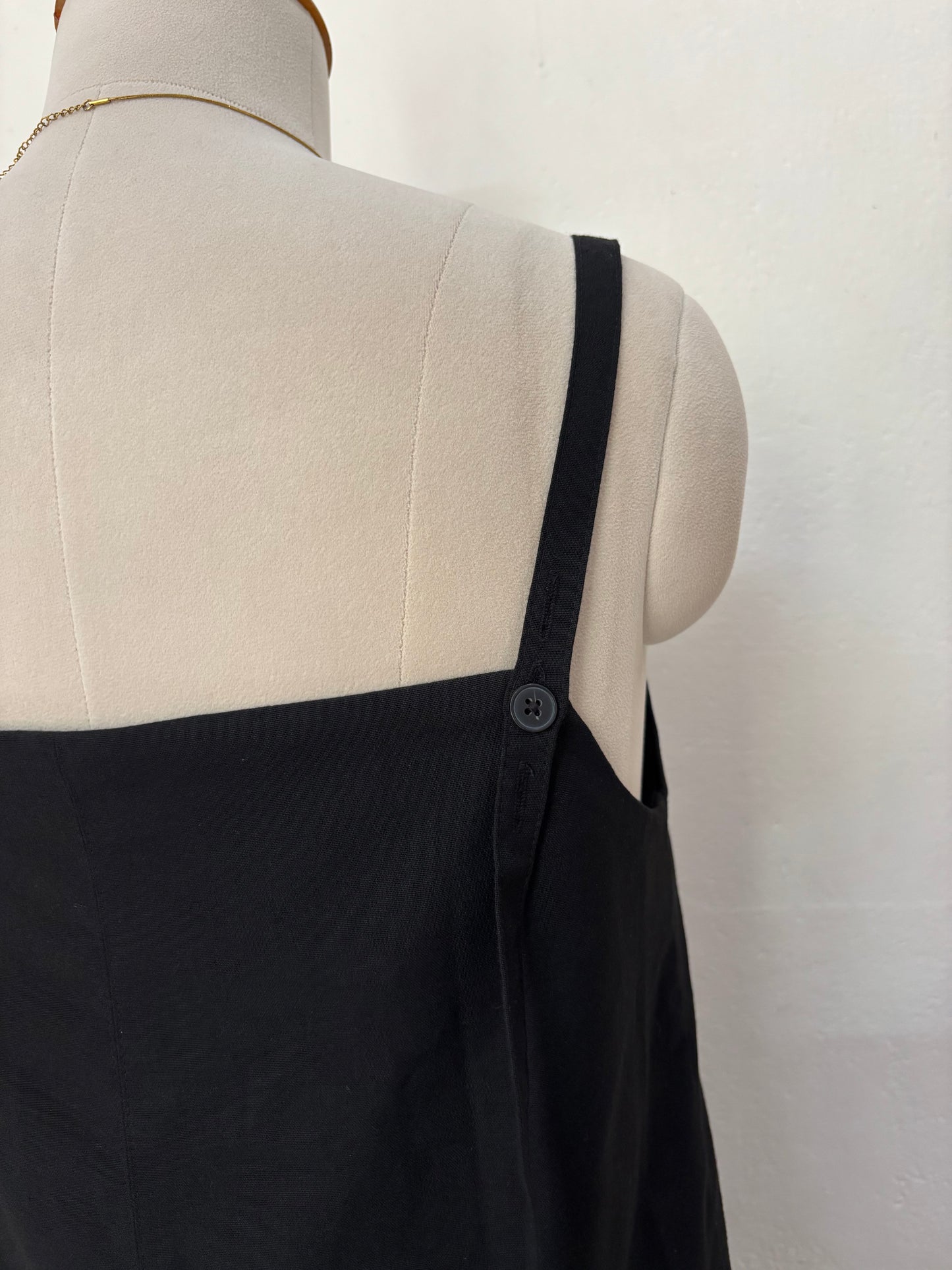 Black short straight cut dress with pleated bottom skirt.