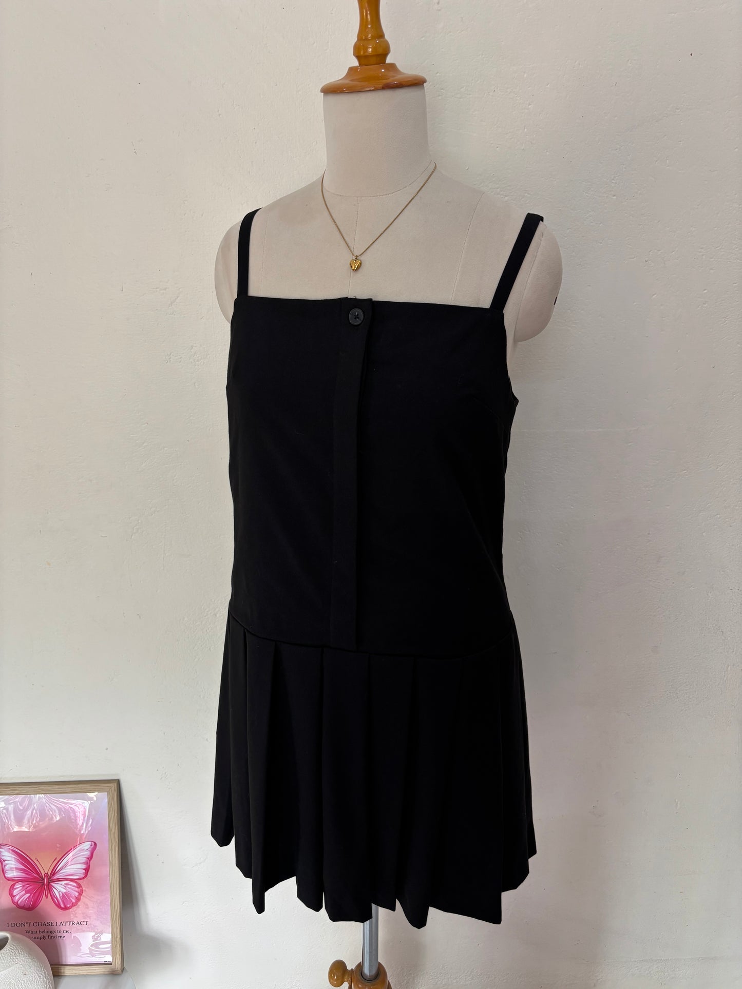 Black short straight cut dress with pleated bottom skirt.