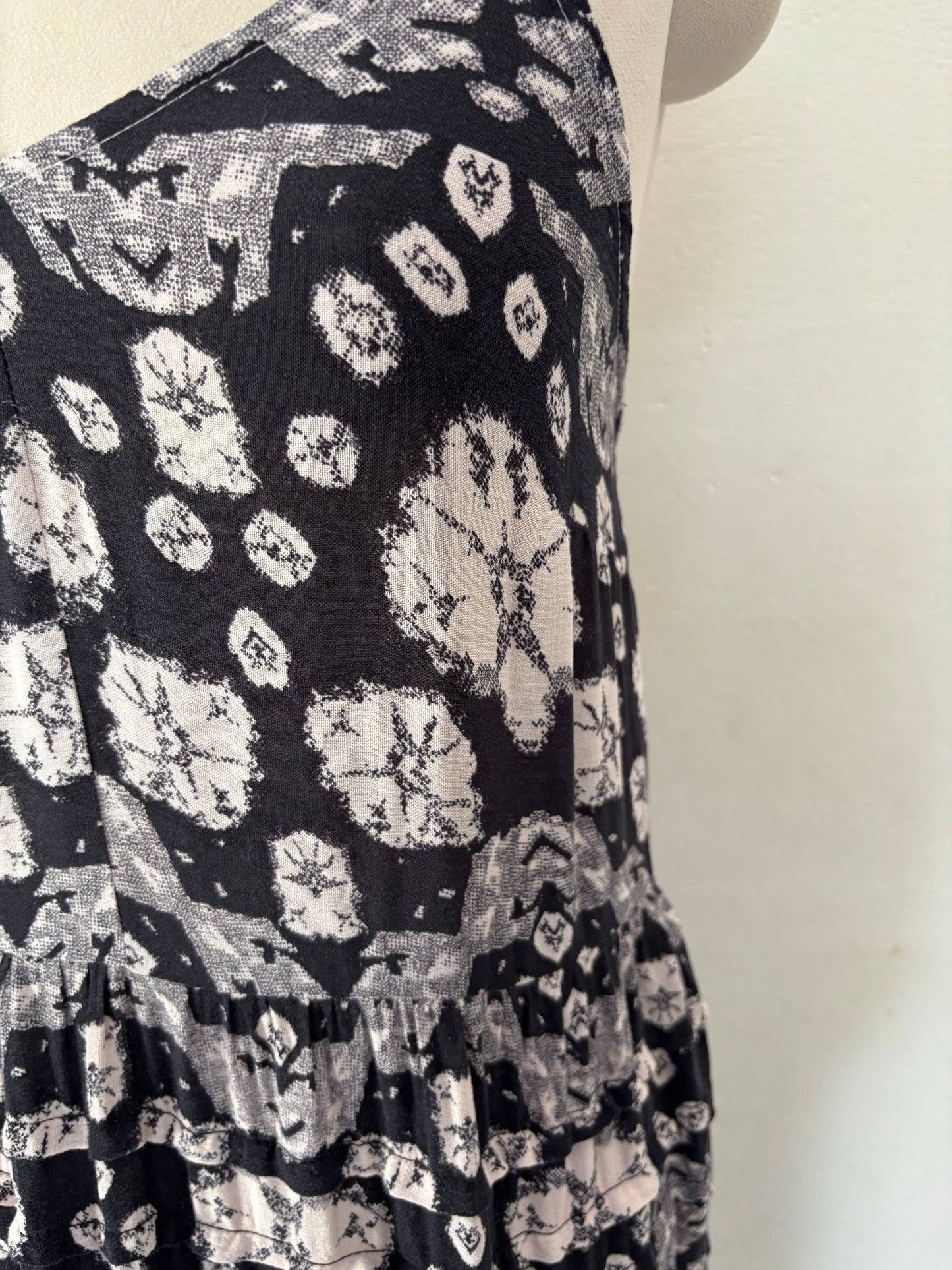 Black and white flared tiered maxi dress with adjustable tie up straps.